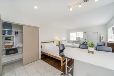 a bedroom with a bed and a living room at Casa Colaretta By At Mine Hospitality in Miami Beach