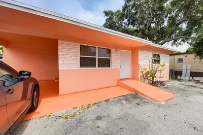 a orange house with a car parked in front of it at 3 Mi to Dania Beach Pier Convenient Apartment! in Dania Beach