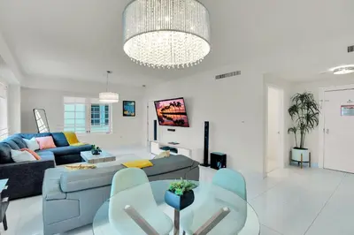 a living room with a blue couch and a table at 2BR Art Deco Retreat Steps Away from the Beach in Miami Beach
