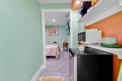 a kitchen with a microwave and a room with a bed at Luxury Miami Studio Next to Beach & Airport in Miami