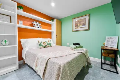 a bedroom with a bed with an orange and green wall at Luxury Miami Studio Next to Beach & Airport in Miami