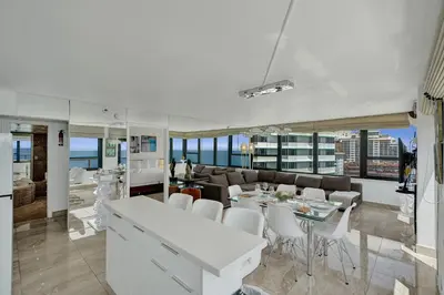 a living room with a couch and a table and chairs at Stylish Oceanfront 2BR 1 and a half BA Condo with Resort Amenities Pools Gym Sauna 1402 in Miami Beach