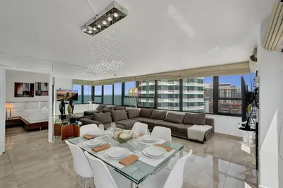 a living room with a table and a couch at Stylish Oceanfront 2BR 1 and a half BA Condo with Resort Amenities Pools Gym Sauna 1402 in Miami Beach