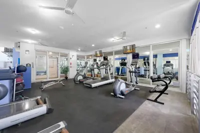 a gym with several treadmills and cardio machines at Luxury Suite - 3 Min Walk to Miami Beach in Miami Beach