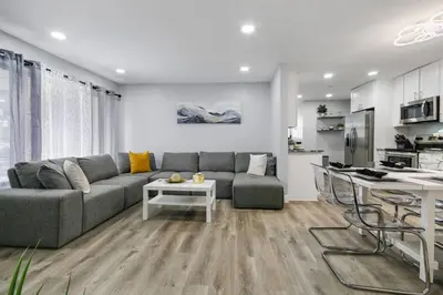 a living room with a gray couch and a kitchen at Renovated Home in Hollywood in Hollywood