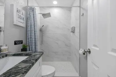 a white bathroom with a shower and a toilet at Renovated Home in Hollywood in Hollywood