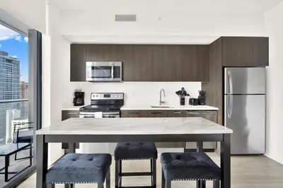 a kitchen with a table and a refrigerator at Elegant studio in the heart of downtown Miami in Miami