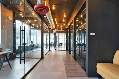 a hallway in a building with glass doors and a person sitting on a couch at Elegant studio in the heart of downtown Miami in Miami