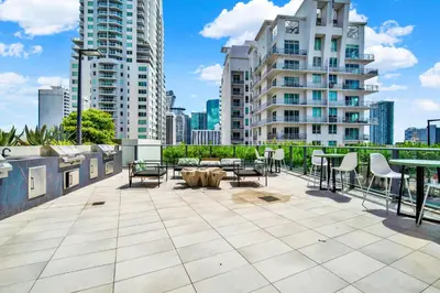 a rooftop patio with tables and chairs and buildings at Elegant studio in the heart of downtown Miami in Miami