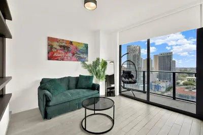 a living room with a green couch and a large window at Elegant studio in the heart of downtown Miami in Miami