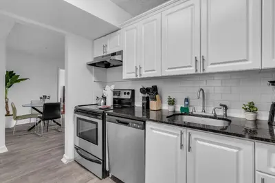a kitchen with white cabinets and a sink at Urban Escape 2 Bed Unit In Miami near Whole Foods in North Miami