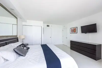a bedroom with a bed with a tv on the wall at Large 2 Bedroom Oceanfront at Roney Palace in South Beach in Miami Beach