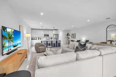 a living room with a large white couch and a kitchen at Casa Bella - New & Stylish Family-Friendly Home in Miami