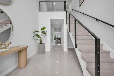 a hallway with white walls and stairs with a mirror at Casa Amoret - Brand New Family-Friendly Retreat in Miami