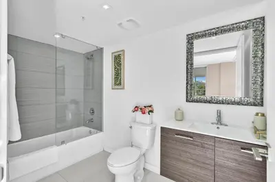 a bathroom with a toilet and a sink and a mirror at Waterfront Luxury Kosher Condo with Rooftop Pool, Bay Harbor Islands in Miami Beach