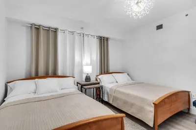 two beds in a room with white walls at Waterview Luxury 2-Bedroom Condo Sunny Isles Beach in Sunny Isles Beach