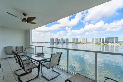 a balcony with a table and chairs and the water at Waterview Luxury 2-Bedroom Condo Sunny Isles Beach in Sunny Isles Beach