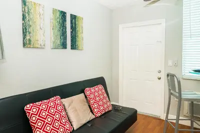 a living room with a black couch with two pillows at 713 Miami Beach Apartments in Miami Beach