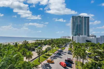 a view of a beach with palm trees and a building at Oceanfront Elegance at W Hotel in Miami Beach