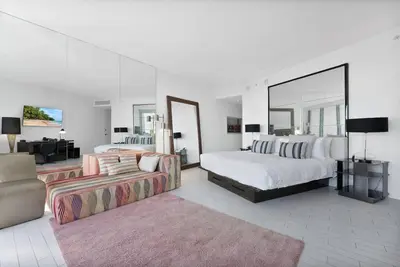 a large white bedroom with two beds and a couch at Oceanfront Elegance at W Hotel in Miami Beach