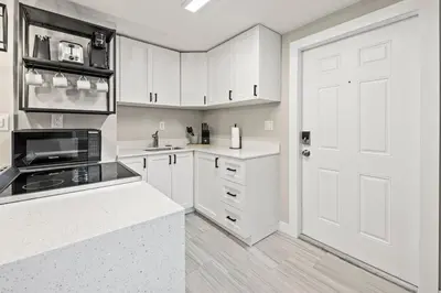a kitchen with white cabinets and a white door at Perfect stay for 2-Walk to Wilton Drive-Shops &bars in Fort Lauderdale