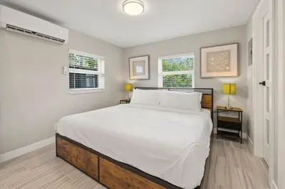 a bedroom with a large white bed with two windows at Perfect stay for 2-Walk to Wilton Drive-Shops &bars in Fort Lauderdale