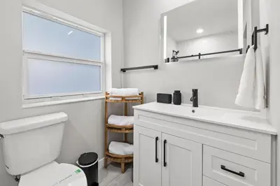 a white bathroom with a sink and a mirror at Perfect stay for 2-Walk to Wilton Drive-Shops &bars in Fort Lauderdale