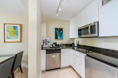 a kitchen with white cabinets and stainless steel appliances at Amazing Intracoastal Views - Walk to the Beach! in Fort Lauderdale