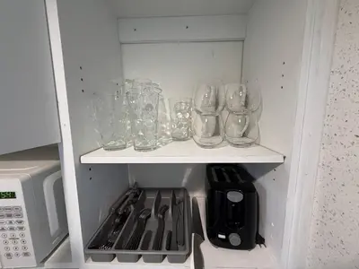 a cupboard filled with glasses and a stove at 1701 - Studio Ocean Front Free Parking Pool in Miami Beach