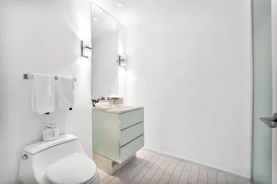 a white bathroom with a toilet and a sink at Stunning Oceanfront 2BR W Hotel in Miami Beach
