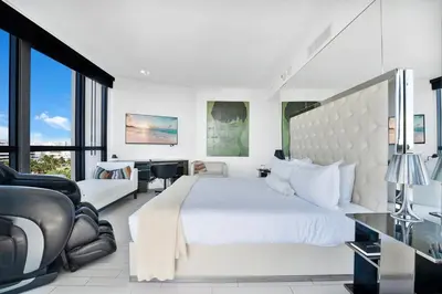 a white bedroom with a large bed and a desk at Stunning Oceanfront 2BR W Hotel in Miami Beach