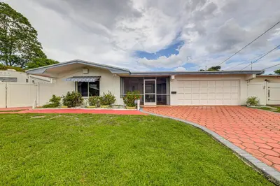 a house with a brick driveway at Canal-Front Gem with Pool 3 Mi to Hard Rock Stadium in Miramar