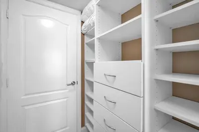 a walk in closet with white cabinets and drawers at Lux condo on 25floor in Brickell in Miami