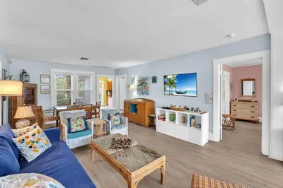 a living room with a blue couch and a table at Bromeliad Bungalow - Downtown Cottage in Fort Lauderdale
