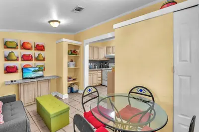 a kitchen and a living room with a table and chairs at Blue Reverie - Downtown Cottage in Fort Lauderdale