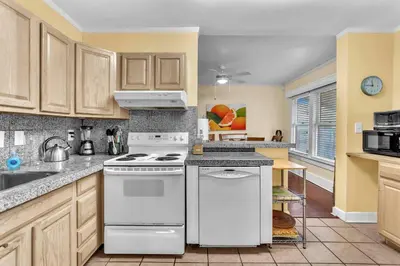 a kitchen with white appliances and wooden cabinets at Blue Reverie - Downtown Cottage in Fort Lauderdale