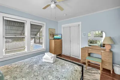 a bedroom with a bed and a dresser and a mirror at Blue Reverie - Downtown Cottage in Fort Lauderdale