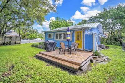a blue tiny house with a table and chairs on a deck at Blue Reverie - Downtown Cottage in Fort Lauderdale