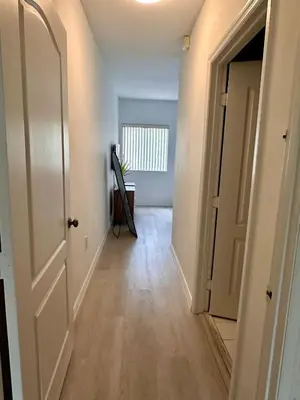 an empty hallway with a white door and a table at Beautiful 2brm condo w free parking fast WiFi in Lindgren Acres