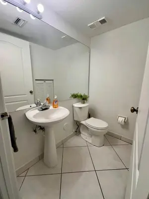 a white bathroom with a toilet and a sink at Beautiful 2brm condo w free parking fast WiFi in Lindgren Acres