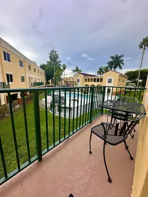 a balcony with a table and chairs and a pool at Beautiful 2brm condo w free parking fast WiFi in Lindgren Acres