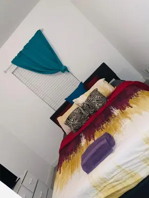 a bed with colorful pillows on it in a room at Miami Fort Lauderdale Vacation Rooms in Miramar