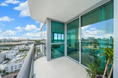 a balcony with glass windows and a view of a city at Stunning Ocean View Private Residence at The Setai - 2002 in Miami Beach