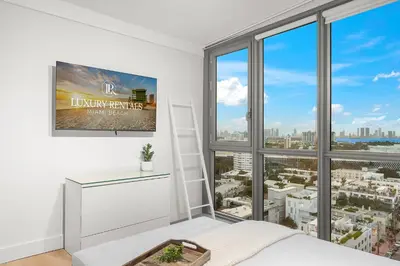 a bedroom with a large window with a view of the city at Stunning Ocean View Private Residence at The Setai - 2002 in Miami Beach