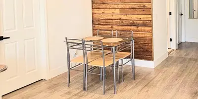 a table and chairs in a room with a wooden wall at Modern 3BR Home Near Holycross Hospital in Fort Lauderdale
