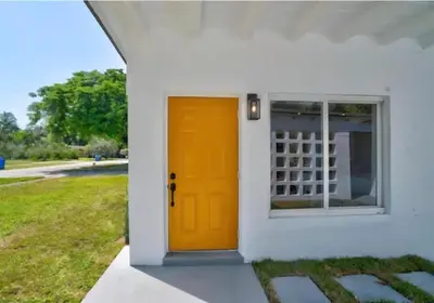 a bright orange door on a white house at Modern 3BR Home Near Holycross Hospital in Fort Lauderdale