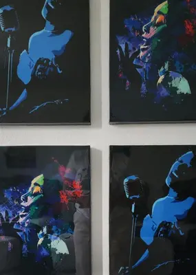a group of four paintings on a wall with a microphone at Magic City IN THE HEART OF MIAMI in Miami
