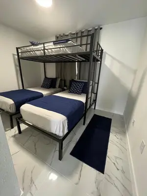 two bunk beds in a room with blue sheets at Magic City IN THE HEART OF MIAMI in Miami
