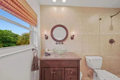 a bathroom with a sink and a mirror and a toilet at Luxe Escape 2BR Fort Lauderdale in Fort Lauderdale