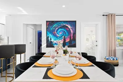 a dining room with a table with chairs and a painting at Cozy 4BR Pool Villa Near The Beach with Arcades in Fort Lauderdale